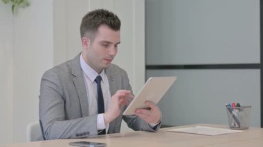 Young Businessman using Digital Tablet for Work