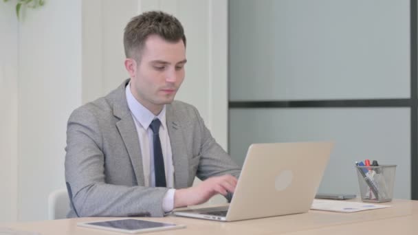 stock video Young Businessman Typing on Laptop in Office