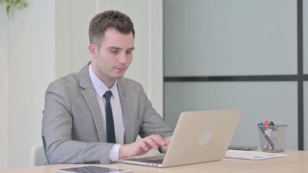 Young Businessman Pointing Camera While Working Laptop — Vídeo de Stock