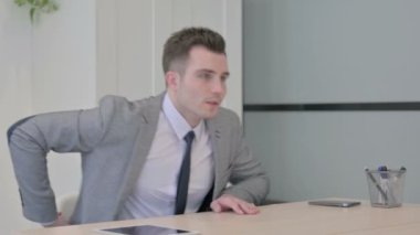 Young Businessman having Back Pain in Office