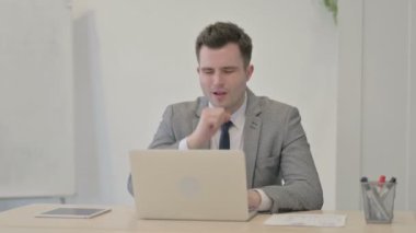 Genç İşadamı Laptop üzerinde çalışırken öksürüyor