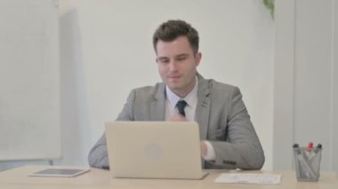 Young Businessman having Toothache while Working on Laptop