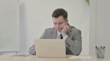 Young Businessman Sleeping while Sitting at Work