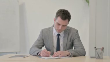 Young Businessman Working on Documents in Office