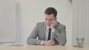 Young Businessman Sleeping while Sitting at Work