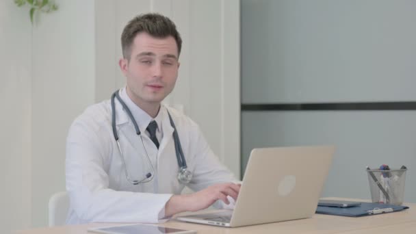 Ung Läkare Tittar Kameran När Använder Laptop — Stockvideo