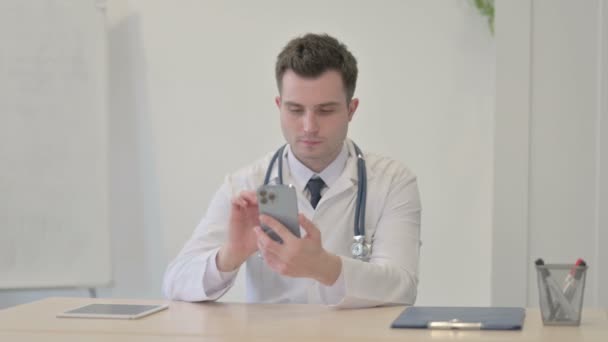 Młody Lekarz Przeglądający Smartfon Klinice — Wideo stockowe