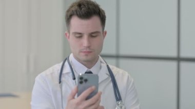 Telefonda konuşan genç doktorun portresi.