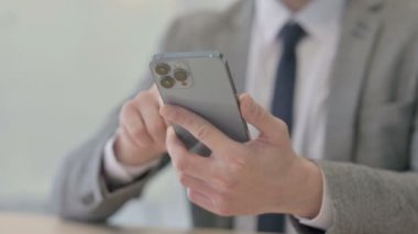 Close up of Young Businessman Browsing Internet on Smartphone