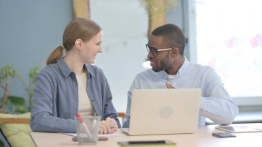 Mixed Race Young Business People Discussing Work on Laptop