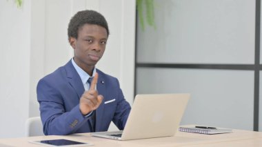 African Businessman Shaking Head in Rejection while Working on Laptop