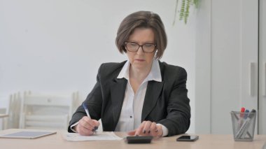 Old Businesswoman Working on Documents, Calculating Business Data