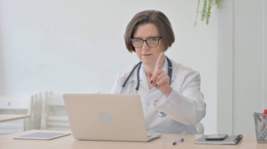 Old Senior Doctor Shaking Head in Rejection while Working on Laptop