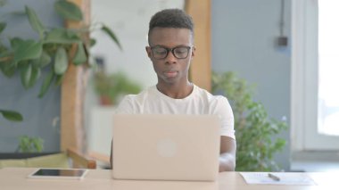 African Man Typing on Laptop in Office