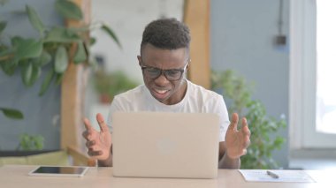 African Man Reacting to Loss While Working in Office