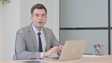 Young Businessman Shocked While Working on Laptop