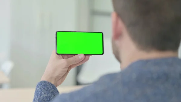 Man Holding Horizontal Smartphone with Green Screen