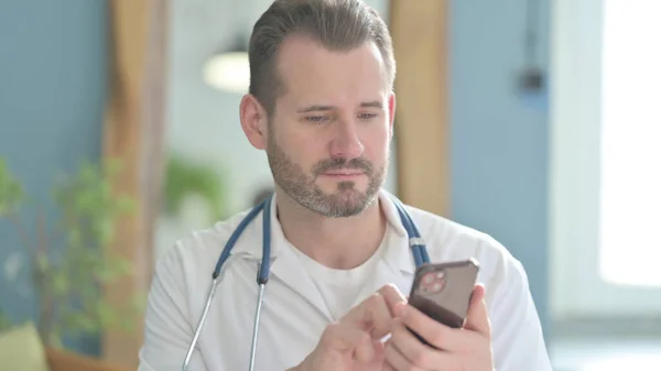 Portrait of Doctor using Smartphone in Clinic