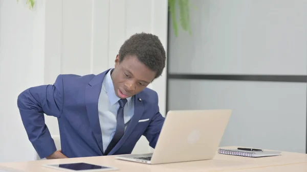 Empresario Africano Que Tiene Dolor Espalda Mientras Usa Ordenador Portátil —  Fotos de Stock