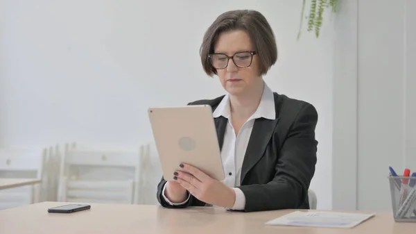 Old Senior Businesswoman using Digital Tablet for Work