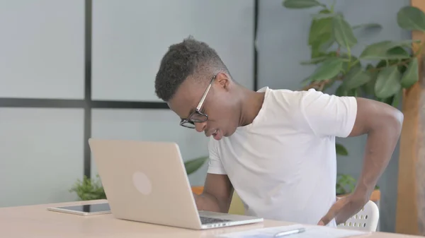 Young African Man with Back Pain at Work