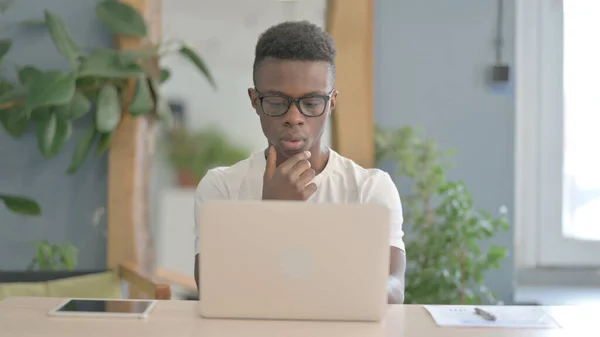 Hombre Africano Pensando Mientras Trabaja Ordenador Portátil —  Fotos de Stock