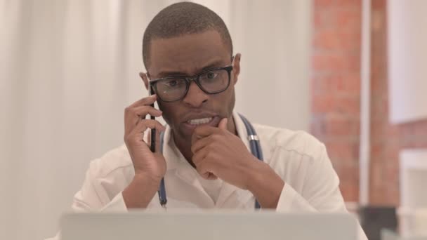 Nahaufnahme Eines Jungen Afrikanischen Arztes Der Mit Dem Laptop Telefoniert — Stockvideo