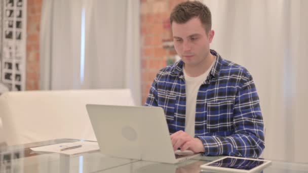 有颈部疼痛的年轻人在笔记本电脑上工作 — 图库视频影像