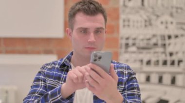 Smartphone kullanan gündelik genç adamın portresi