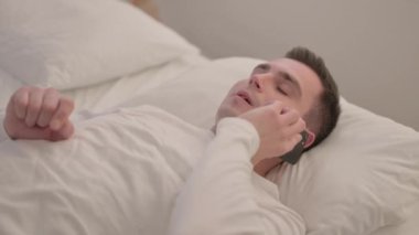 Yatakta telefonda konuşan genç adam