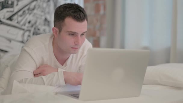 Jovem Trabalhando Laptop Enquanto Deitado Estômago Cama — Vídeo de Stock