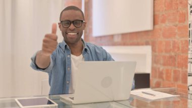 Dizüstü bilgisayardaki Afrikalı Adam Başparmağını kaldırdı