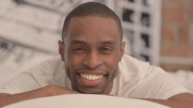 Afrikalı Adam Yatakta Mide Üstünde Uzanıyor Kamerada Gülümsüyor