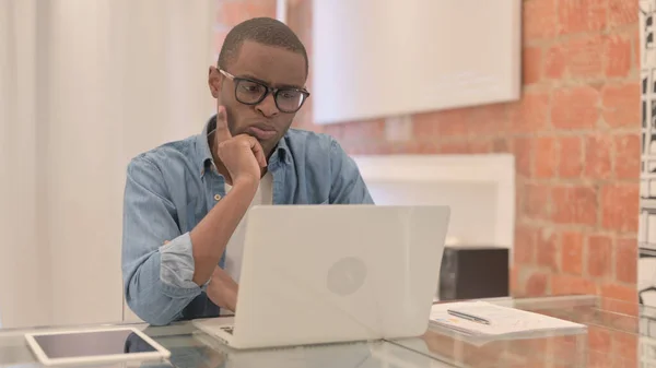 Hombre Africano Pensando Trabajando Ordenador Portátil —  Fotos de Stock