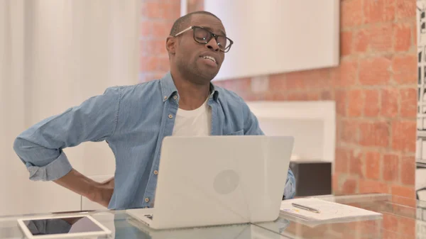 stock image African Man with Back Pain Working on Laptop