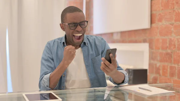非洲男人在智能手机上庆祝成功 — 图库照片