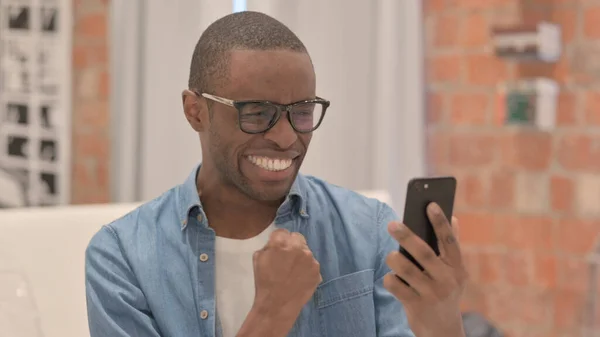 非洲男人用智能手机庆祝成功的肖像 — 图库照片