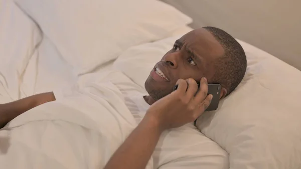 Upset African Man Arguing Phone Bed — Stock Photo, Image