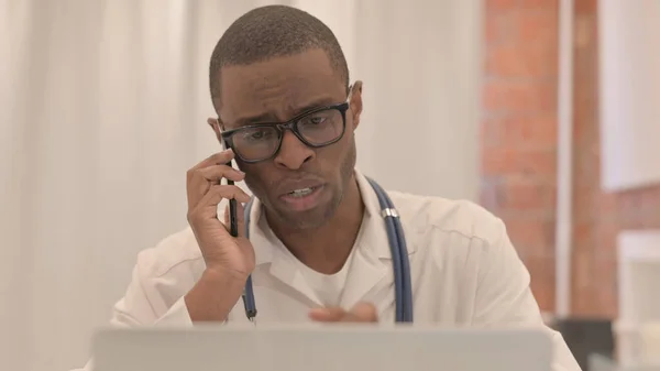 Primer Plano Del Joven Médico Africano Hablando Por Teléfono Mientras —  Fotos de Stock