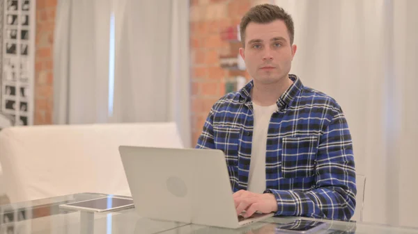 stock image Young Casual Man Working on Laptop Looking toward Camera