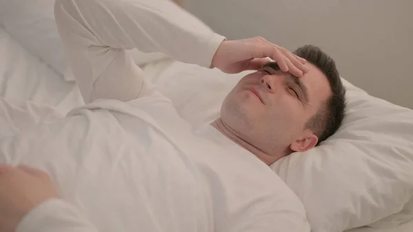 Baş Ağrısı Olan Genç Adam Yatakta Yatıyor — Stok fotoğraf
