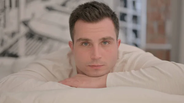 Serious Young Man Lying Bed Stomach Looking Camera — Stock Photo, Image