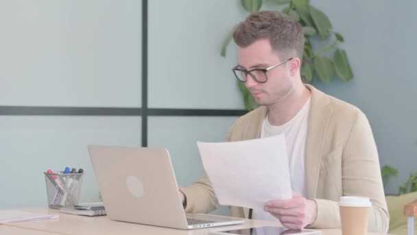 Ung Affärsman Firar Framgång Laptop Och Dokument Pappersarbete — Stockvideo