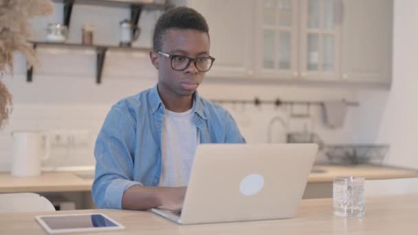 Νεαρός Αφρικανός Που Εργάζεται Στο Laptop Κοιτάζοντας Προς Την Κάμερα — Αρχείο Βίντεο