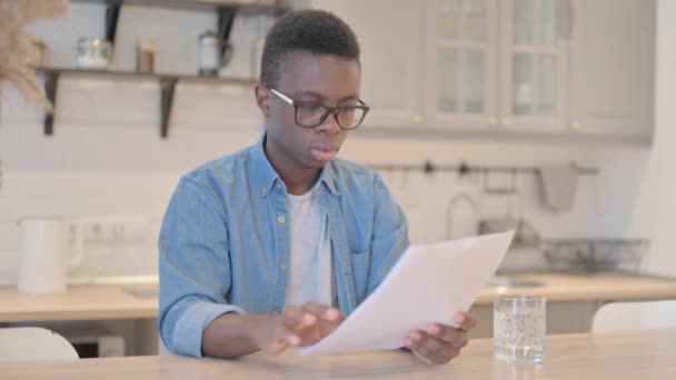 Ung Afrikansk Man Firar När Han Reagerar Affärsrapporten — Stockvideo