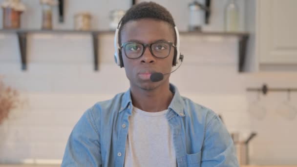 Νεαρός Αφρικανός Ακουστικά Κοιτάζοντας Προς Την Κάμερα Στο Τηλεφωνικό Κέντρο — Αρχείο Βίντεο