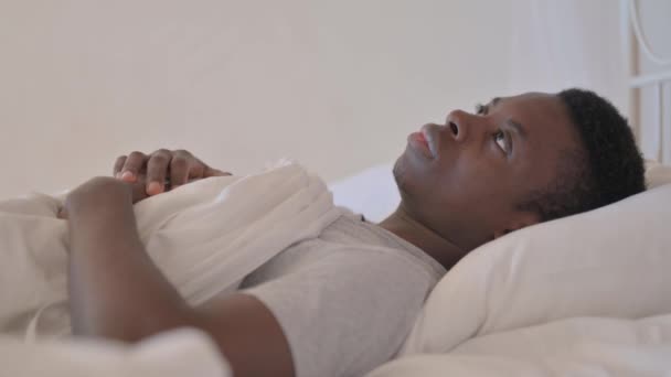 Πλευρική Άποψη Του Pensive Young African Man Κοιμάται Στο Κρεβάτι — Αρχείο Βίντεο