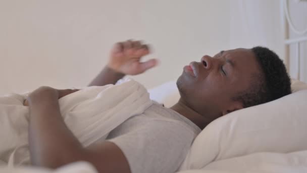 ベッドで頭痛を持つ若いアフリカ人男性のサイドビュー — ストック動画