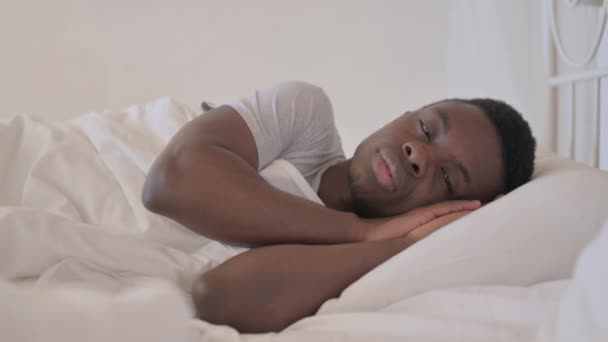 Σοβαρός Νεαρός Αφρικανός Ξαπλωμένος Στο Κρεβάτι Στο Πλάι — Αρχείο Βίντεο