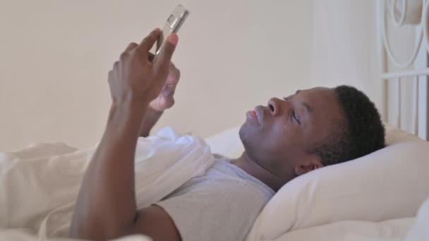 Side View Young African Man Χρησιμοποιώντας Τηλέφωνο Στο Κρεβάτι — Αρχείο Βίντεο